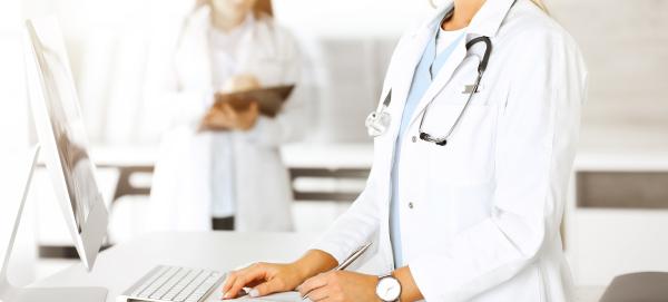 doctors-taking-note-on-computer-and-paper