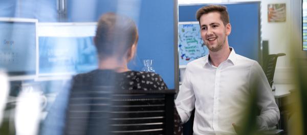 two employees talking in an office