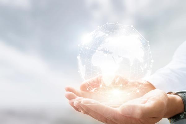 two hands holding a holographic globe