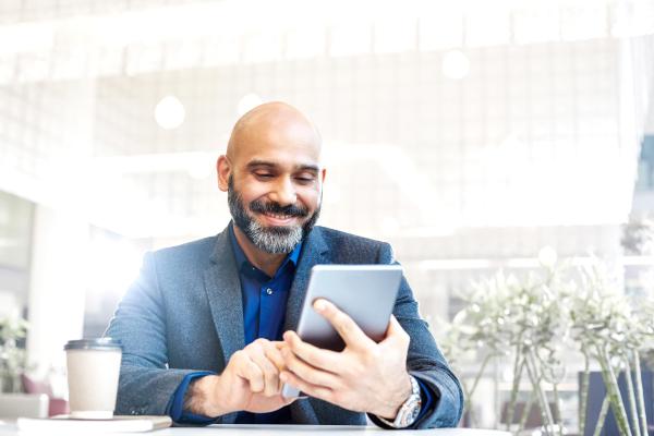 man smiling using an ipad