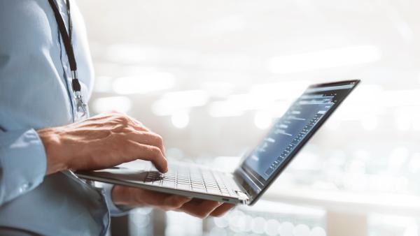 hand holding computer and touching the keyboard