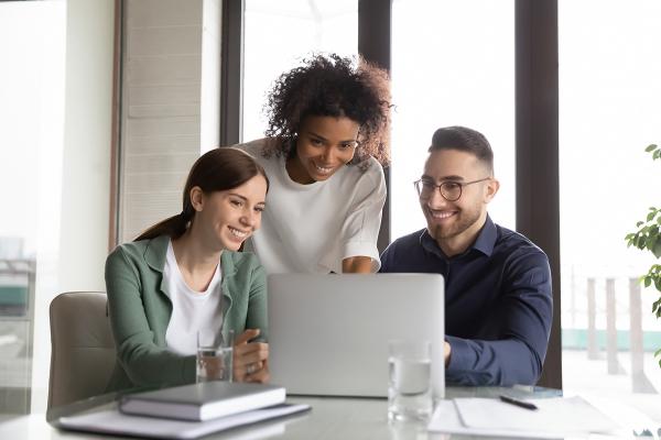 three people looking at a laptop