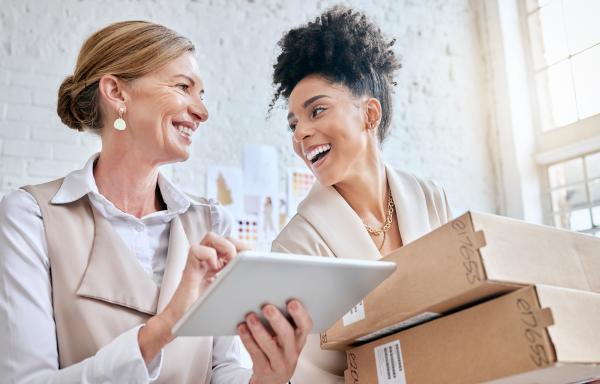 two women smiling carrying some packages