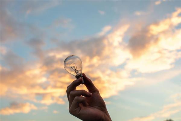 a hand holding a light bulb