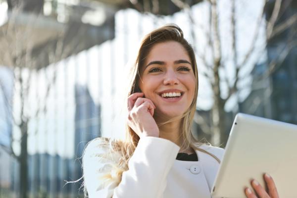 woman smiling holding a tablet