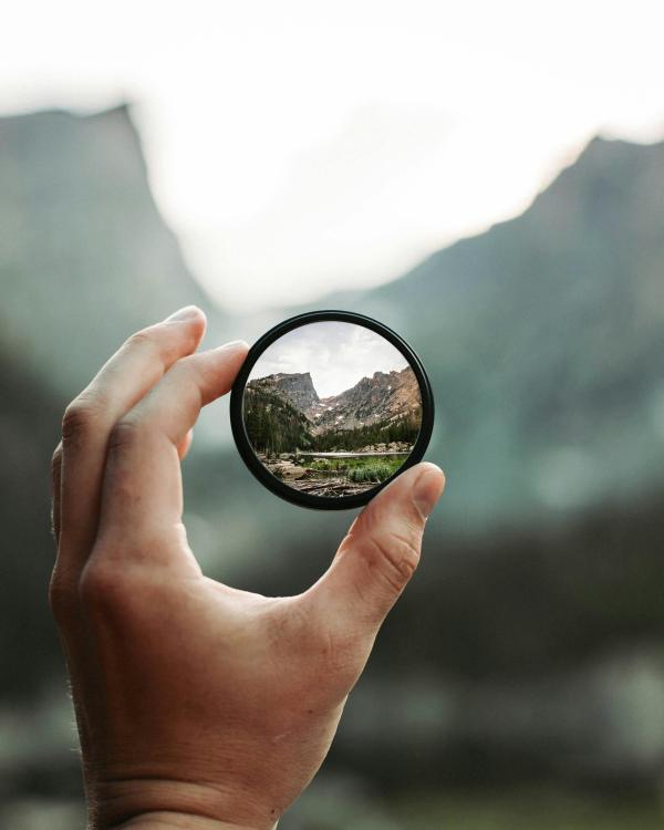 hand holding a rounded magnifying glass