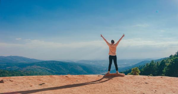 man standing up in the mountains