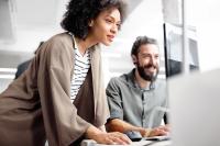 woman and man looking at the screen