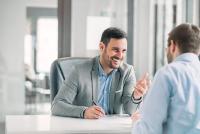 business man smiling while talking to another man