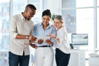 three people looking at a tablet